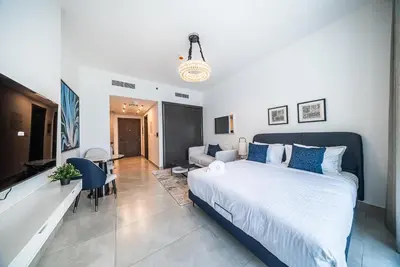 a bedroom with a large bed and a living room at Modern Studio I Smart Home I Business Bay in Dubai