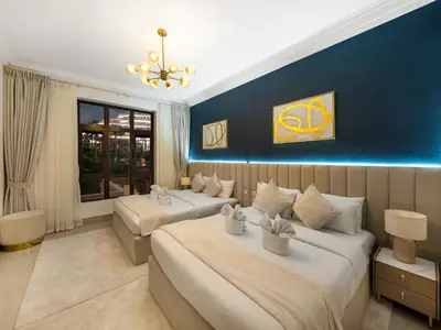 a bedroom with two beds and a blue wall at Luxury 2BR- Pool with Burj View- 2 Min to Dubai Mall in Dubai