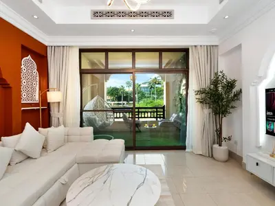 a living room with a white couch and a table at Luxury 2BR- Pool with Burj View- 2 Min to Dubai Mall in Dubai