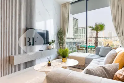 a living room with a couch and a tv on a wall at Bloomfields Modern 1Br Binghatti Onyx in Dubai