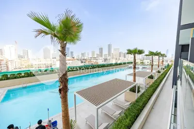 a swimming pool with palm trees on a building at Bloomfields Modern 1Br Binghatti Onyx in Dubai