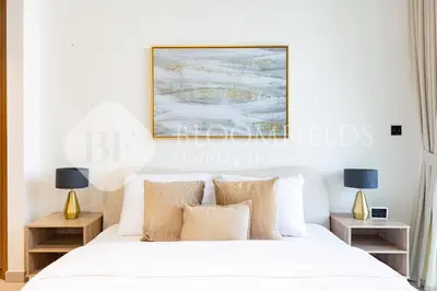 a bedroom with a white bed with two night stands at Bloomfields Modern 1Br Binghatti Onyx in Dubai