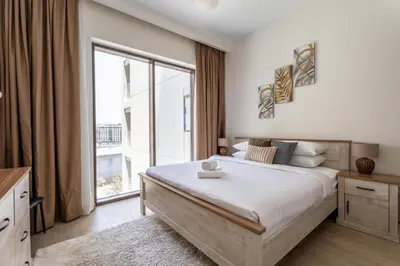 a bedroom with a large bed and a large window at GuestReady - Charming stay at Creek Beach in Dubai