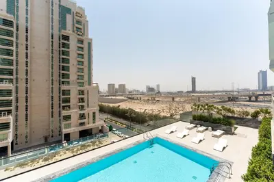 a swimming pool on the roof of a building with buildings at Smart Home 1BR with Pool and City View in JVC by Bhavan Vacation Homes in Dubai