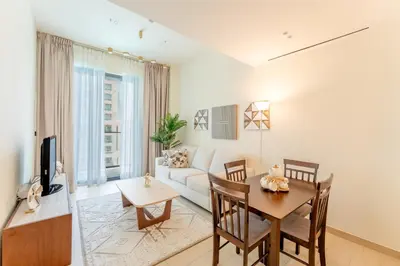 a living room with a table and a couch at Smart Home 1BR with Pool and City View in JVC by Bhavan Vacation Homes in Dubai