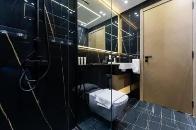 a black bathroom with a toilet and a shower at Smart Home 1BR with Pool and City View in JVC by Bhavan Vacation Homes in Dubai