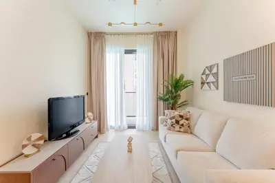 a living room with a couch and a tv at Smart Home 1BR with Pool and City View in JVC by Bhavan Vacation Homes in Dubai