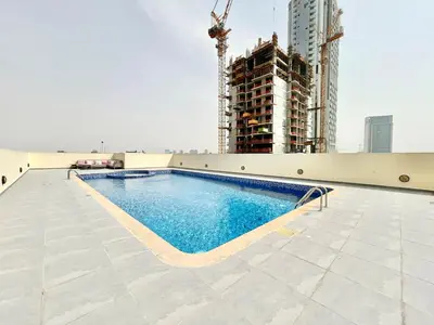 a swimming pool on the roof of a building at Homes2Retreat - Modern Studio with Balcony in JVT in Dubai