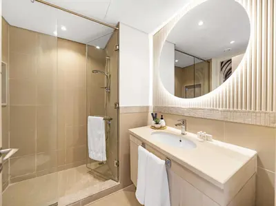 a bathroom with a sink and a shower and a mirror at Kensington 2BR walk to Dubai Mall via Link in Dubai