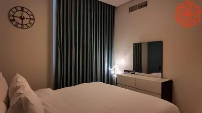 a bedroom with a bed and a clock on the wall at pearl 1bdr apartment in business bay in Dubai