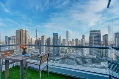 a balcony with a table and chairs and a city skyline at Panoramic Marina Views Walk to Beach and JBR 1BR in Dubai