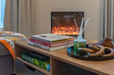 a coffee table with books and pretzels and a fireplace at Panoramic Marina Views Walk to Beach and JBR 1BR in Dubai