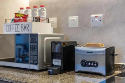 a microwave and a toaster oven on a counter at Panoramic Marina Views Walk to Beach and JBR 1BR in Dubai