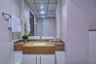 a bathroom with a sink and a mirror at Panoramic Marina Views Walk to Beach and JBR 1BR in Dubai