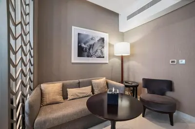 a living room with a couch and a table and a chair at Canal Bliss Balcony View in Dubai