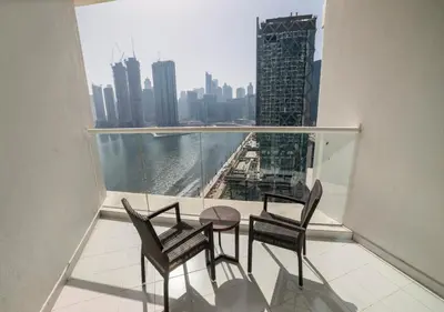 a balcony with a table and chairs and a view of a city at Canal Bliss Balcony View in Dubai