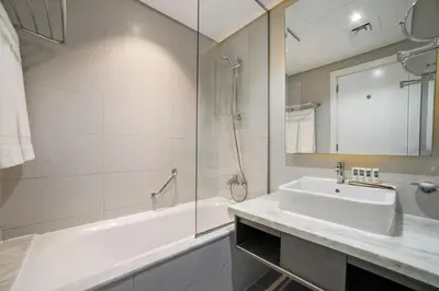 a bathroom with a sink and a shower and a tub at Canal Bliss Balcony View in Dubai