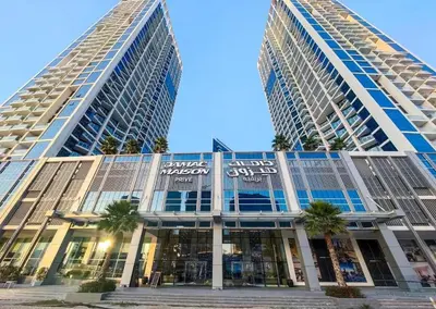 two tall buildings with palm trees in front of them at Canal Bliss Balcony View in Dubai
