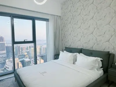 a bedroom with a large bed with a large window at Stylish & Comfy Downtown Oasis Views, Pool & Gym in Dubai