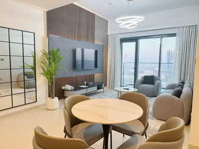 a living room with a table and chairs at Stylish & Comfy Downtown Oasis Views, Pool & Gym in Dubai