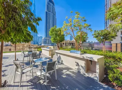 a patio with chairs and tables with a view of a city at Stylish & Comfy Downtown Oasis Views, Pool & Gym in Dubai