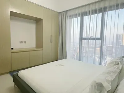 a bedroom with a bed and a large window at Stylish & Comfy Downtown Oasis Views, Pool & Gym in Dubai