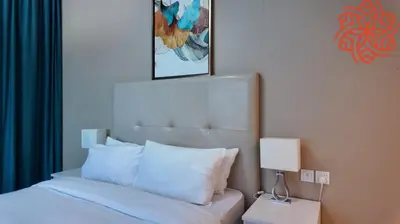a bedroom with a bed with white sheets and a lamp at Amazing 1bdr apartment in business bay in Dubai