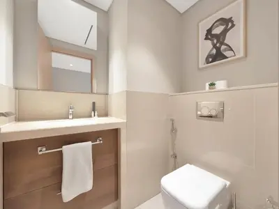 a bathroom with a toilet and a sink and a mirror at Kensington 1BR and Study with Sofa Bed Burj View Dubal mall link in Dubai