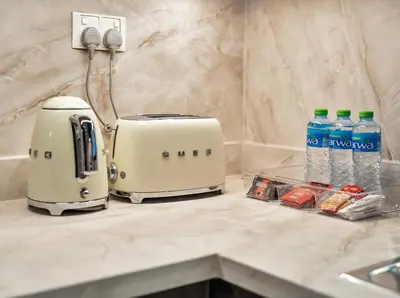 a toaster and water bottles on a kitchen counter at Kensington 1BR and Study with Sofa Bed Burj View Dubal mall link in Dubai