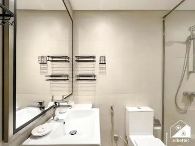 a bathroom with a sink and a toilet and a mirror at Serene Luxe l Modern 1BR in Meydan with Pool in Dubai
