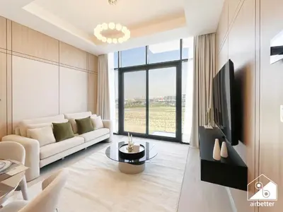 a living room with a white couch and a tv at Serene Luxe l Modern 1BR in Meydan with Pool in Dubai