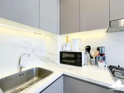 a kitchen with a sink and a microwave at Serene Luxe l Modern 1BR in Meydan with Pool in Dubai