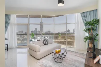 a living room with a couch and a large window at Bright and Cozy 1BHK JVC by Czechin Great Location in Dubai
