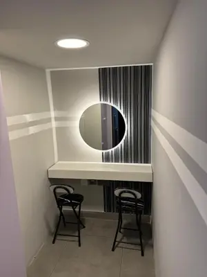 a bathroom with a vanity with two chairs and a mirror at Modern Private Hostel Room near Business Bay Downtown in Dubai