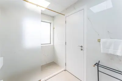 a white bathroom with a shower and a glass door at Veluxa - Beautiful 2Bed in JBR in Dubai