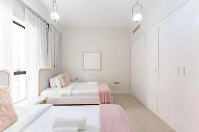 a white bedroom with a bed and a window at Veluxa - Beautiful 2Bed in JBR in Dubai
