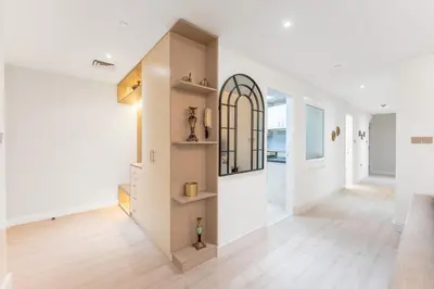 a hallway of a home with white walls and wooden floors at Veluxa - Beautiful 2Bed in JBR in Dubai