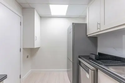 a kitchen with white cabinets and a stainless steel refrigerator at Veluxa - Beautiful 2Bed in JBR in Dubai