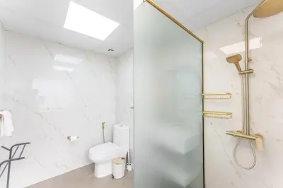 a white bathroom with a shower and a toilet at Veluxa - Beautiful 2Bed in JBR in Dubai