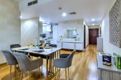 a kitchen and dining room with a table and chairs at Marina View, 2BR Ideal for Groups, Walk to beach in Dubai