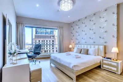 a bedroom with a bed and a desk and a window at Marina View, 2BR Ideal for Groups, Walk to beach in Dubai