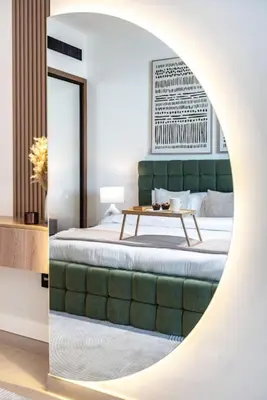 a bedroom with a bed and a table in a mirror at Large 1BR, Pool View, Near Circle Mall, Parking in Dubai