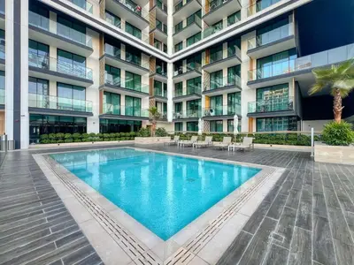 a swimming pool in front of a building at Large 1BR, Pool View, Near Circle Mall, Parking in Dubai