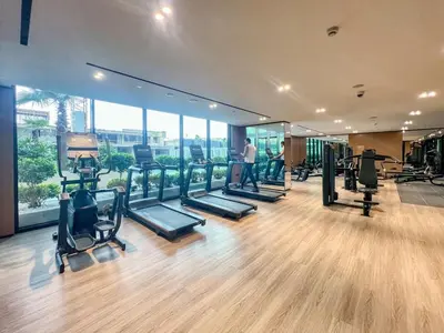 a gym with several treadmills and a man standing in a room at Large 1BR, Pool View, Near Circle Mall, Parking in Dubai