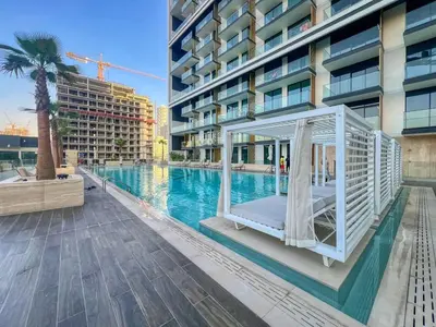 a swimming pool with a canopy bed in front of a building at Large 1BR, Pool View, Near Circle Mall, Parking in Dubai