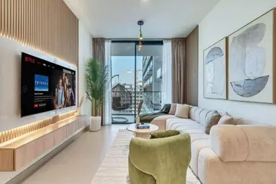 a living room with a couch and a tv at Large 1BR, Pool View, Near Circle Mall, Parking in Dubai