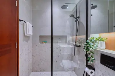 a bathroom with a shower with a glass door at Family and Group Friendly Near Beach Metro and Marina in Dubai