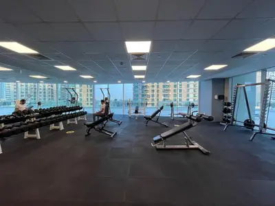 a gym with treadmills and people exercising in it at Family and Group Friendly Near Beach Metro and Marina in Dubai