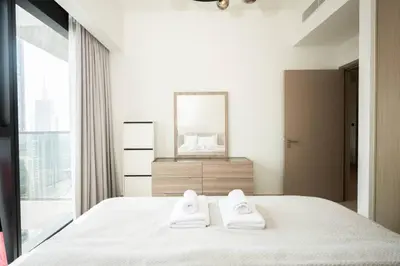 a bedroom with a bed with two white towels on it at High-Rise Apartment by Burj and Fountain in Dubai