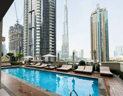 a swimming pool on the roof of a building with tall buildings at High-Rise Apartment by Burj and Fountain in Dubai